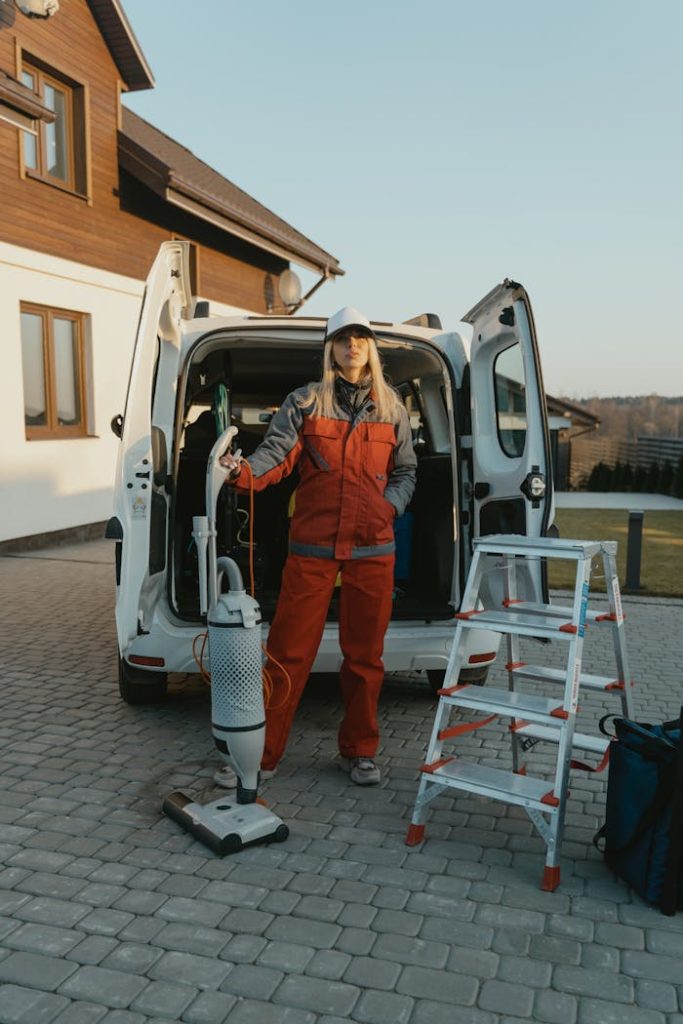 a woman of Luminex Cleaning in orange jumpsuit vacuuming a floor | Residential Cleaning | used for luminexcleaning.nl